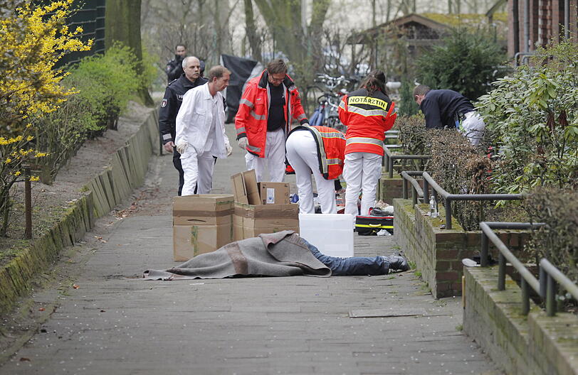Sanitäter am Tatort in Hamburg. Im Vordergrund die zugedeckte Leiche des mutmaßlichen Schützen.