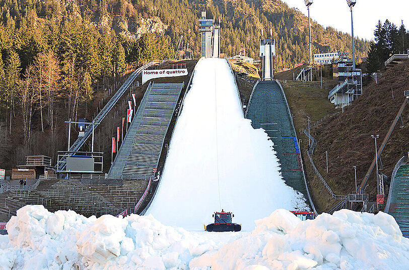 Die schneebedeckte Schanze in der so gar nicht verschneiten Landschaft inmitten von Oberstdorf.