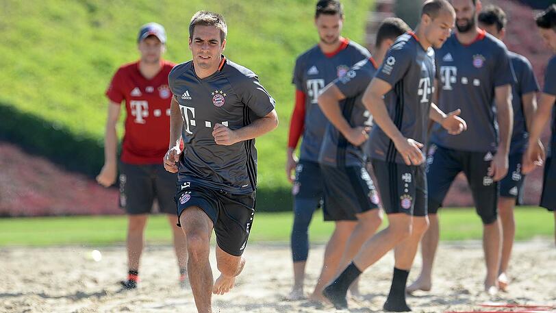 Kapitän Philipp Lahm chreitet voran, während sich die Mannschaft im Hintergrund erholt.