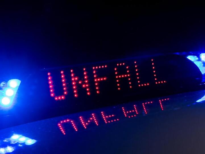 Zwischen einem Polizeifahrzeug warnt eine Leuchtschrift vor einem Unfall. Foto: Monika Skolimowska/Archivbild