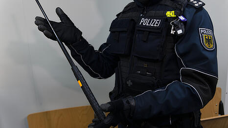 Ein Polizist zeigt einen Teleskopschlagstock. In Deutschland ist diese Waffe verboten.