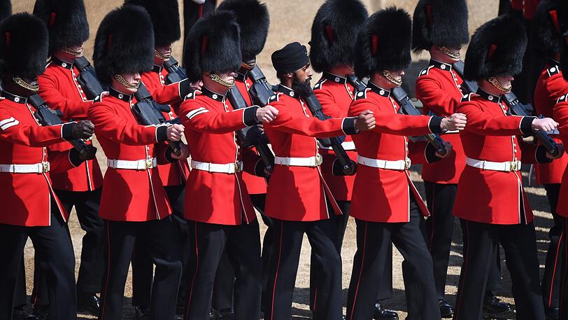 Mitglieder der Coldstream-Garde, darunter auch Charanpreet Singh Lall mit Turban, marschieren für die Queen.