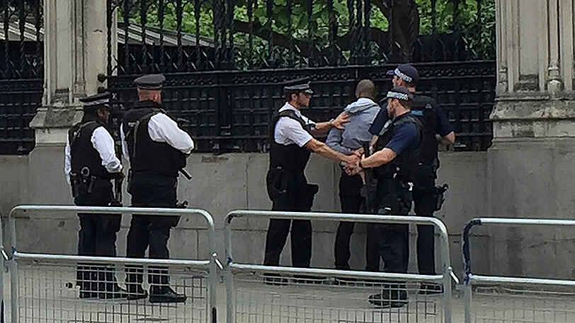 Polizisten nehmen vor dem Parlament in London einen Mann fest. Er war möglicherweise bewaffnet.