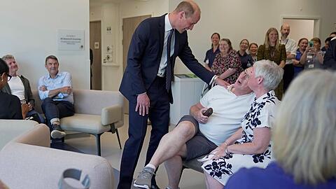 Prinz William scherzt mit einem Patienten beim Besuch in einem Krebszentrum.