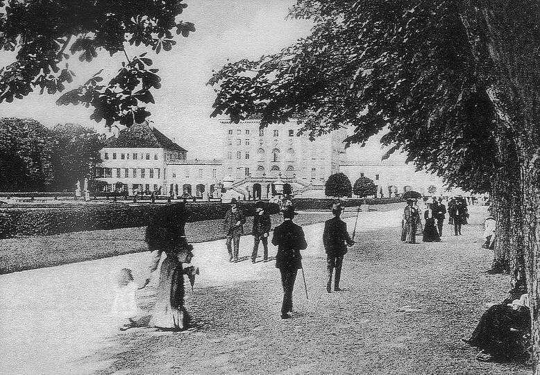 Spaziergänger flanieren vor dem Nymphenburger Schloss.