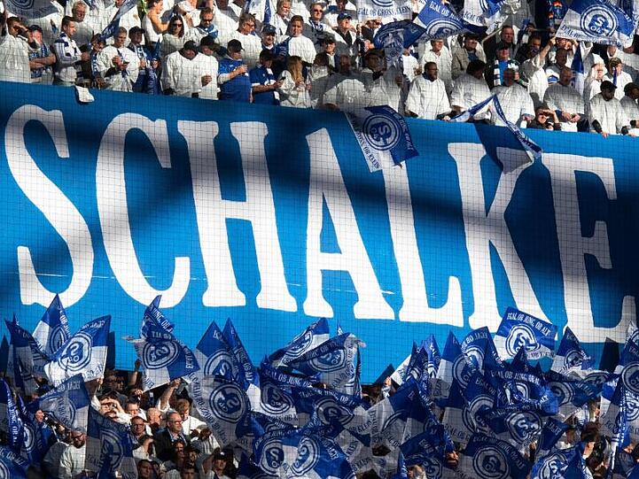 Der finanziell angeschlagene Bundesligaverein soll eine Bürgschaft erhalten - Schalke-Fans schwenken Fahnen.