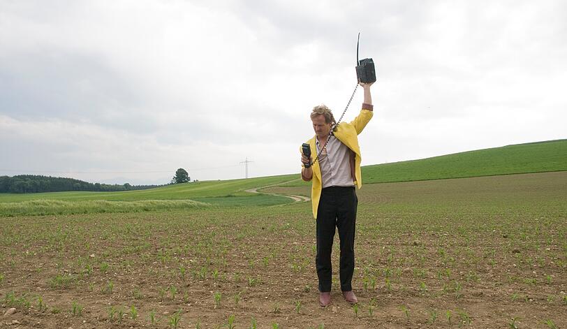 Hansi (Maximilian Brückner) ist verzweifelt auf der Suche nach Empfang für sein Handy.