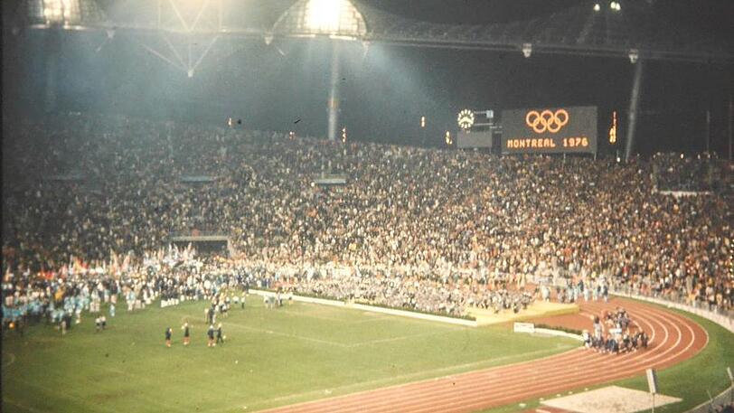 Die Schlussfeier der Athleten. Auf der Anzeigetafel wird der Ort der folgenden Olympischen Sommerspiele eingeblendet: Montreal 1976.
