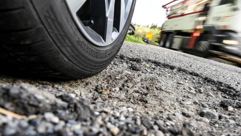 Ein Auto steht neben einer Bundesstraße in einem Schlagloch. Foto: Felix Kästle/Archivbild Ein Auto steht neben einer Bundesstraße in einem Schlagloch. Foto: Felix Kästle/Archivbild