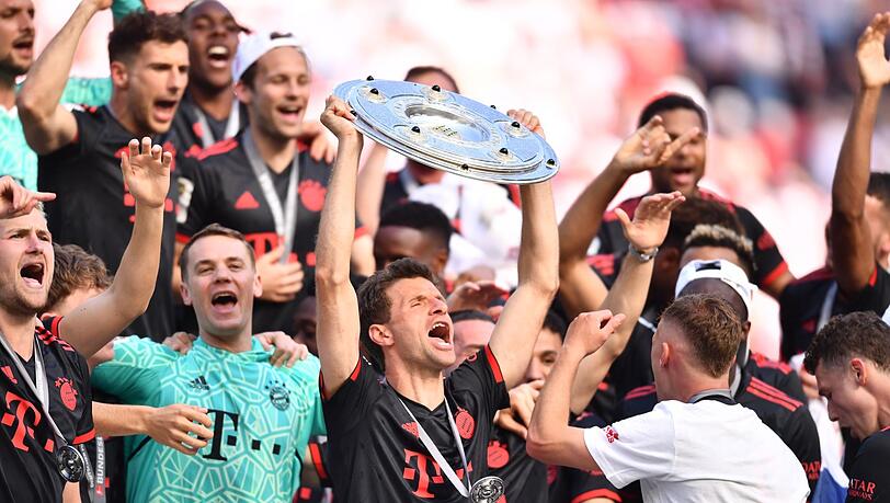 Bayerns Thomas Müller (M) hält die Meisterschale hoch während seine Teamkollegen nach dem Gewinn der 33. deutschen Meisterschaft jubeln.