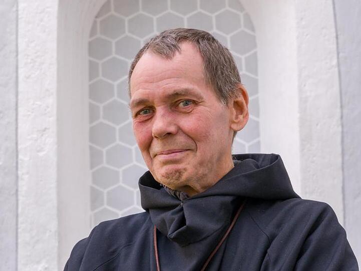 Bruder Damian steht vor der Kirche Mariä Heimsuchung. Foto: Peter Kneffel/dpa/Archivbild