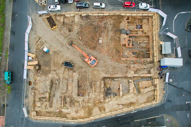 Ausgrabung: In Hannover haben Archäologen mitten unter einer viel befahrenen Straße bei Reparaturarbeiten Überreste alter Siedlungen gefunden. Von oben ergibt sich ein Bild einer alten Stadt.