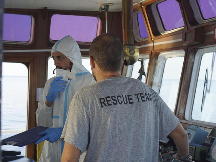 An Bord des Rettungsschiffes "Open Arms": Ein Mitarbeiter des italienischen Gesundheitsministeriums berät die Lage mit einem Besatzungsmitglied.
