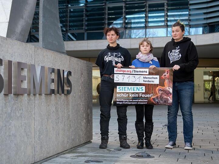 Drei "Fridays for Future"-Aktivisten vor dem Siemens-Hauptsitz in München. Foto: Tobias Hase/dpa
