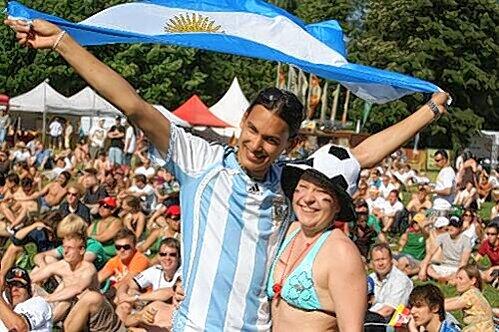 Feiern und strahlen mit der Sonne um die Wette: Louis und Melli beim Public Viewing auf der Wöhrder Wiese mit wehender Fahne.