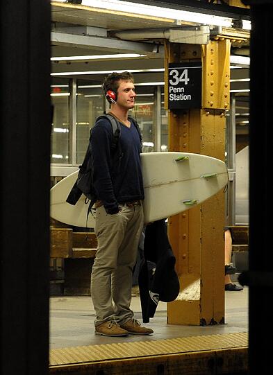 "Nicht ohne mein Surfbrett" - ein New Yorker auf dem Weg zu den Notunterkünften.