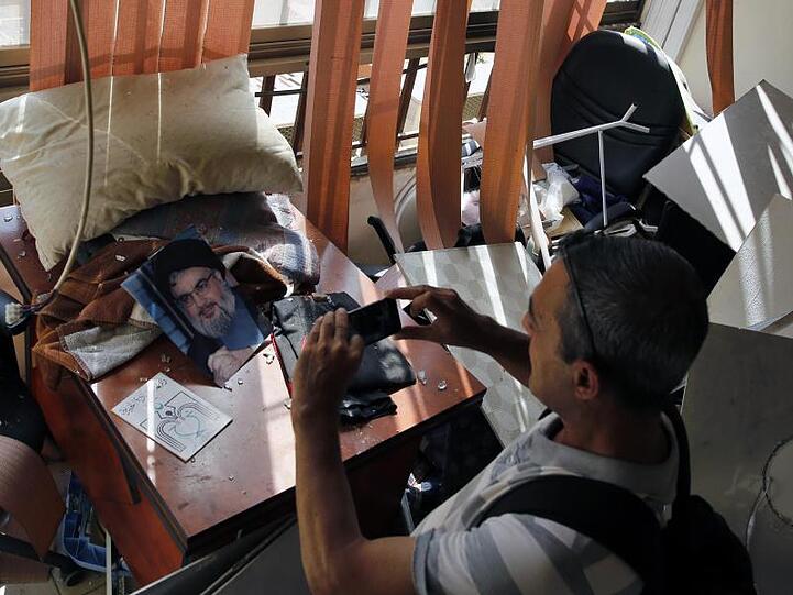 Ein Journalist macht Fotos von den Schäden in einem Medienbüro der Hisbollah-Miliz, wo eine israelische Drohne abgestürzt ist.