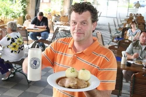 Markus Reif präsentiert auf seiner verglasten Terrasse am liebsten Schweinebraten mit Kloß - und dazu ein frisch gezapftes Tucher-Bier.