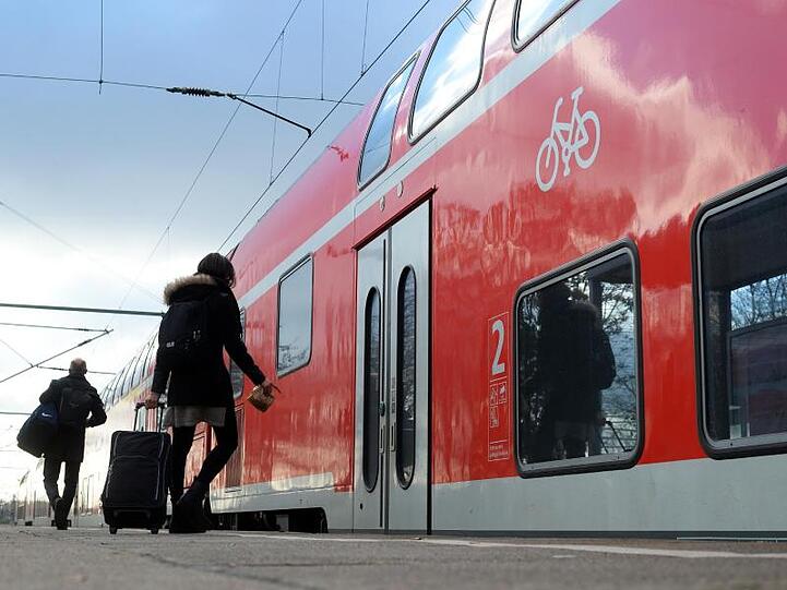 Reisende steigen in einen Regio-Zug.