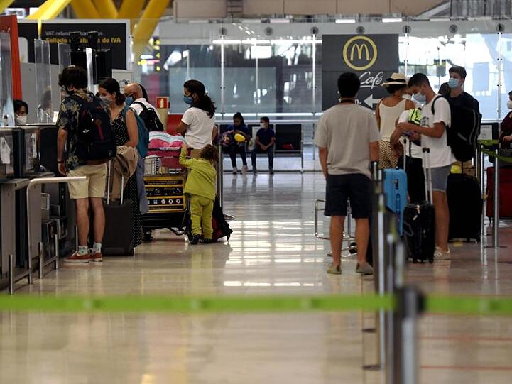 Reisende stehen an den Check-in-Schaltern im Terminal T1 des Flughafens in Madrid.