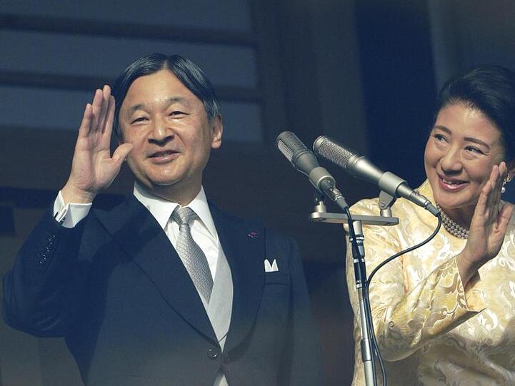 Japans Kaiser Naruhito mit Kaiserin Masako winken vom kugelsicheren Balkon.