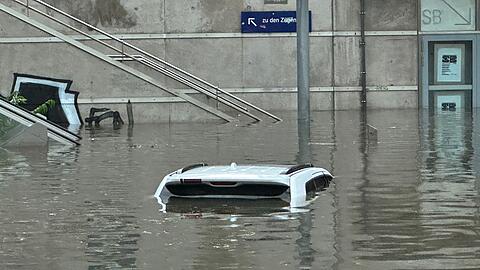 Ein Auto steht in einer überschwemmten Unterführung.