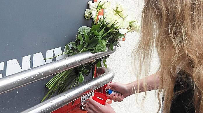 Weiße Rosen und Kerzen: Vor dem Penny in Sendling zündet eine junge Frau ein Grablicht an für die Münchnerin (31), die hier am Montagabend von Polizisten erschossen wurde. Die Frau war zuvor mit einem Küchenmesser auf die Beamten losgegangen.