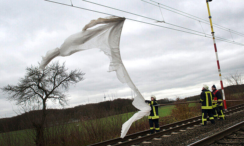 Eine Plane hat sich bei starken Windböen in Schamede (Nordrhein-Westfalen) von einem landwirtschaftlichen Betrieb gelöst und in der Oberleitung der Bahnstrecke verfangen.