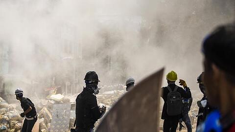 Demonstranten stehen vor rauchenden Trümmern einer provisorischen Barrikade bei einem Anti-Putsch-Protest in Yangon. Myanmarische Sicherheitskräfte haben heute erneut Waffengewalt gegen eine Demonstration gegen die Militärjunta eingesetzt.