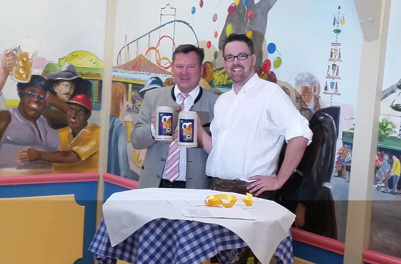 Wiesn-Chef Josef Schmid (l.) und Kabarettist André Hartmann mit dem neuen Wiesn-Krug.