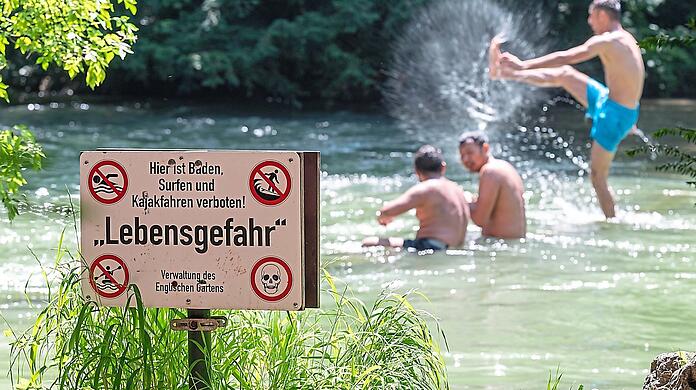 Warnschilder am Ufer weisen auf die Gefahr hin. Doch gleichzeitig planschen Badegäste ausgelassen im Wasser. Vielen erscheint deshalb das Badeverbot übertrieben.