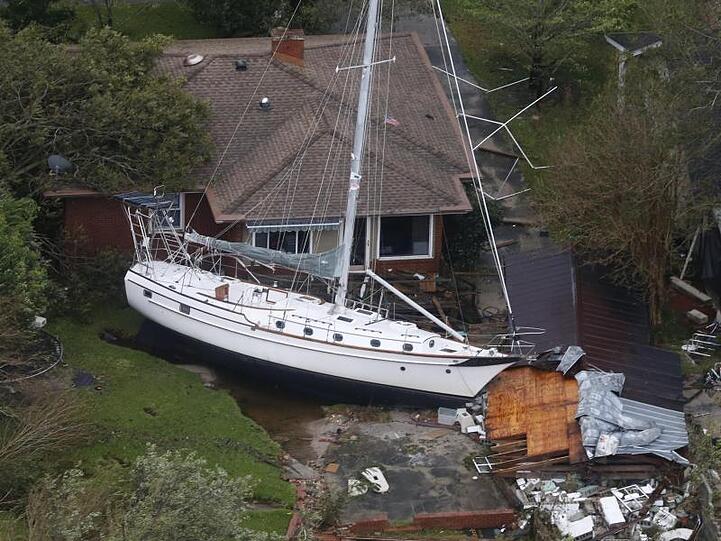 Ein Segelboot liegt nach dem Hurrikan "Florence" in den USA vor einem Wohnhaus.