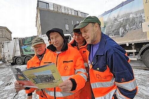 Fürther Müllmänner blättern im Jubiläumskalender.