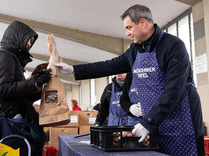 Markus Söder (CSU,r), Ministerpräsident von Bayern, besucht die Ausgabestelle der Münchner Tafel. Foto: Sven Hoppe/dpa