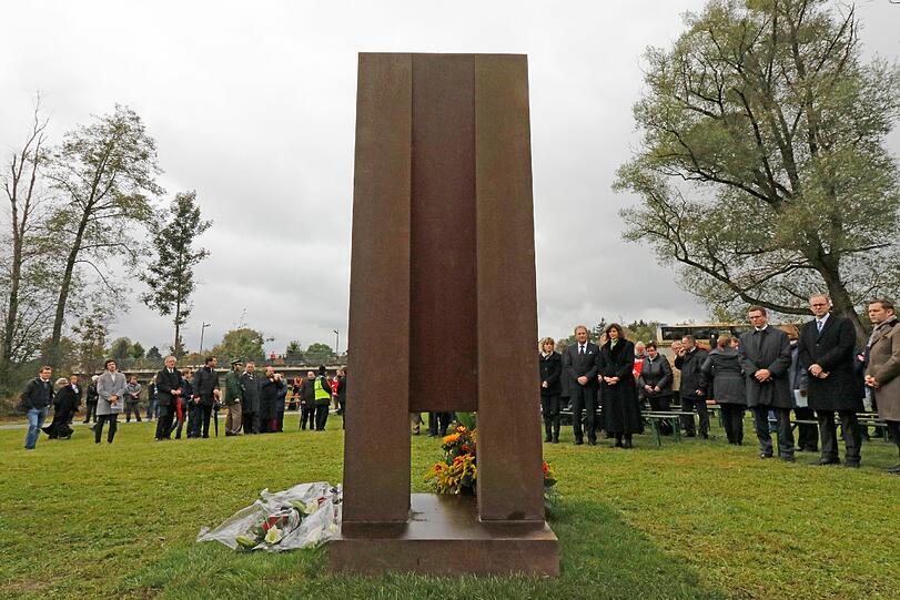 Teilnehmer des Festaktes stehen am 07.10.2016 in Bad Aibling (Bayern) während der Einweihung eines Mahnmals für die Opfer des Zugunglücks vor der Gedenkstätte. Die rund drei Meter hohe Skulptur des Künstlers Franz Ferdinand Wörle erinnert unweit der Unfallstelle an das Zugunglück mit 12 Toten.