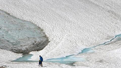 Zwei Wanderer gehen über den Schneeferner-Gletscher auf der Zugspitze. Foto: Stephan Jansen/dpa/Archivbild