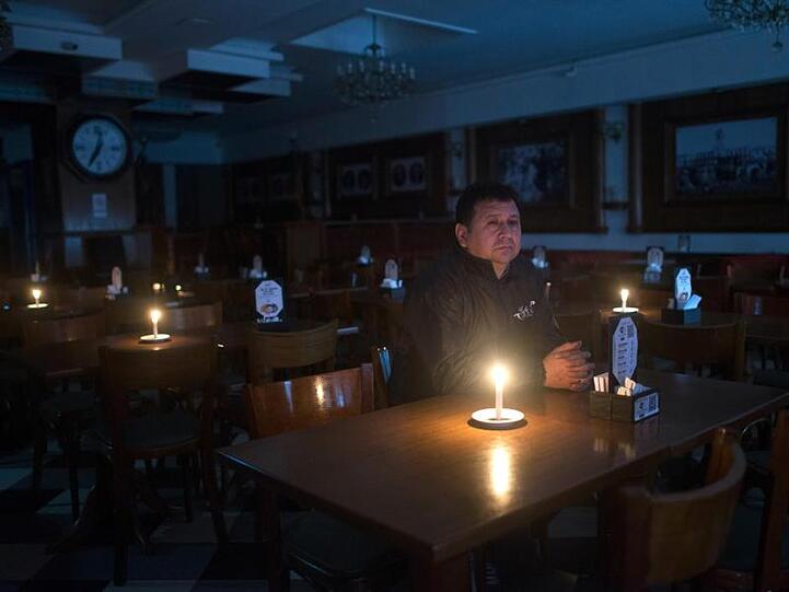Ein Kunde sitzt in einer Bar in Buenos Aires während eines Stromausfalls. In Teilen Südamerikas ist es am Sonntag zu einem massiven Stromausfall gekommen.