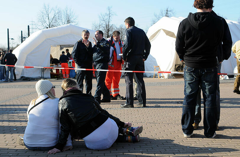 Jugendliche sitzen vor Sanitätszelten am Einkaufszentrum CentrO in Oberhausen.