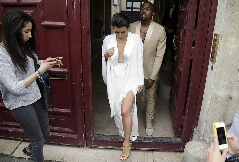...Kim Kardashian und Kanye West (im cremefarbenen Anzug) in Paris auf dem Weg zum Hochzeitsmarathon (l.).