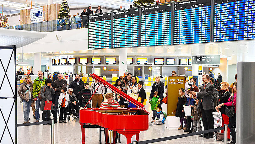 Der rote Steinway-Flügel unter der Anzeigetafel im Terminal 2 des Münchner Flughafens. Der rote Steinway-Flügel unter der Anzeigetafel im Terminal 2 des Münchner Flughafens.