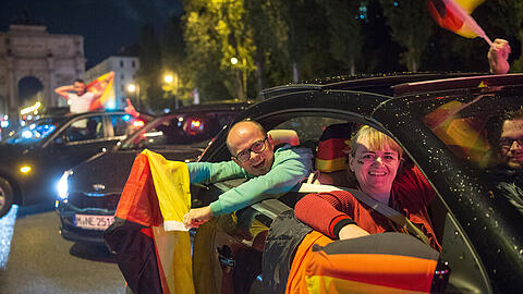Deutsche Fußballfans fahren nach dem Sieg im Viertelfinalspiel der DFB-Elf gegen Italien im Autokorso über die Leopoldstraße in München.