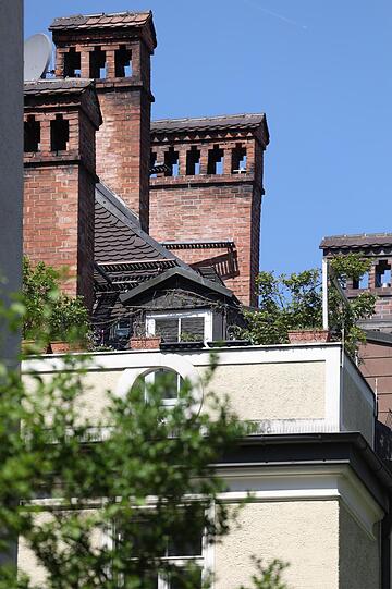 Blick in einen Hinterhof auf wunderschöne alte, gemauerte Kamine.