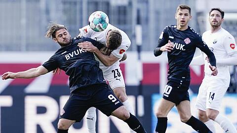 Würzburgs Dominic Baumann (l) und Sandhausens Nils Röseler (2.v.l.) kämpfen um den Ball.
