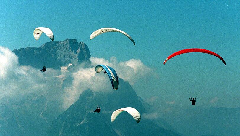 Gleitschirmflieger vor dem Zugspitzmassiv. Gleitschirmflieger vor dem Zugspitzmassiv.