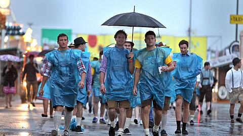 Trotz Sauwetter und Regen kamen viele auf die Wiesn. Das nasskalte Wetter des ersten Wiesntags ließ viele Besucher zum Schirm greifen - oder zum Taschentuch.