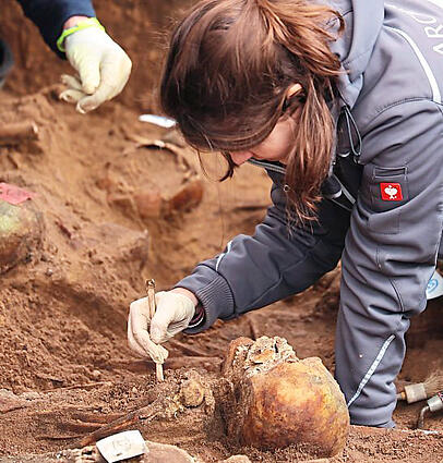 Eine Archäologin legt die menschlichen Überreste frei. Eine Archäologin legt die menschlichen Überreste frei.