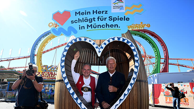 Oberbürgermeister Dieter Reiter (SPD) (r) und Wiesnchef Christian Scharpf stehen in einem Fass beim Presserundgang über das Oktoberfestgelände vor dem Olympia-Looping.
