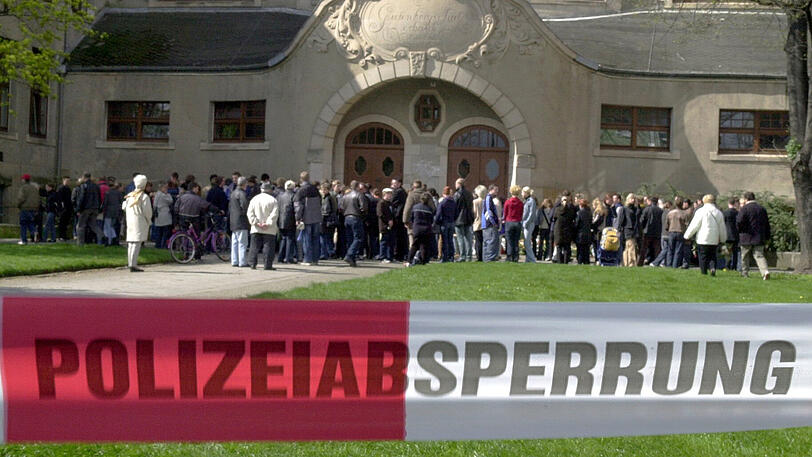 27.04.2002, Thüringen, Erfurt: Ein Absperrband der Polizei trennt vor dem Gutenberg-Gymnasium in Erfurt Medienvertreter von Trauernden.