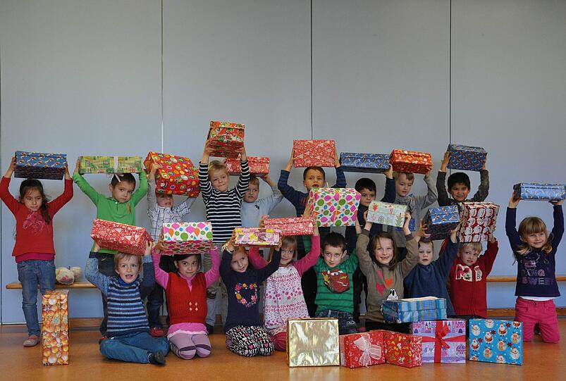 Die Kinder packen Geschenkboxen für Sendlinger Familien.