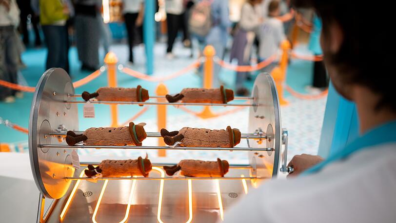 Bevor die Plüsch-Bratwürste verkauft werden, landen sie auf einem (unechten) Grill. Bevor die Plüsch-Bratwürste verkauft werden, landen sie auf einem (unechten) Grill.